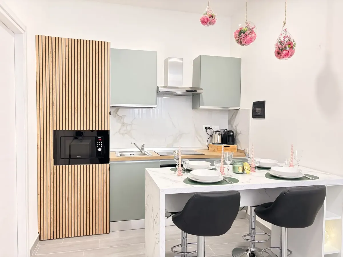 La cucina del nostro appartamento in via Beinette, con microonde, piano cottura e penisola con sgabelli