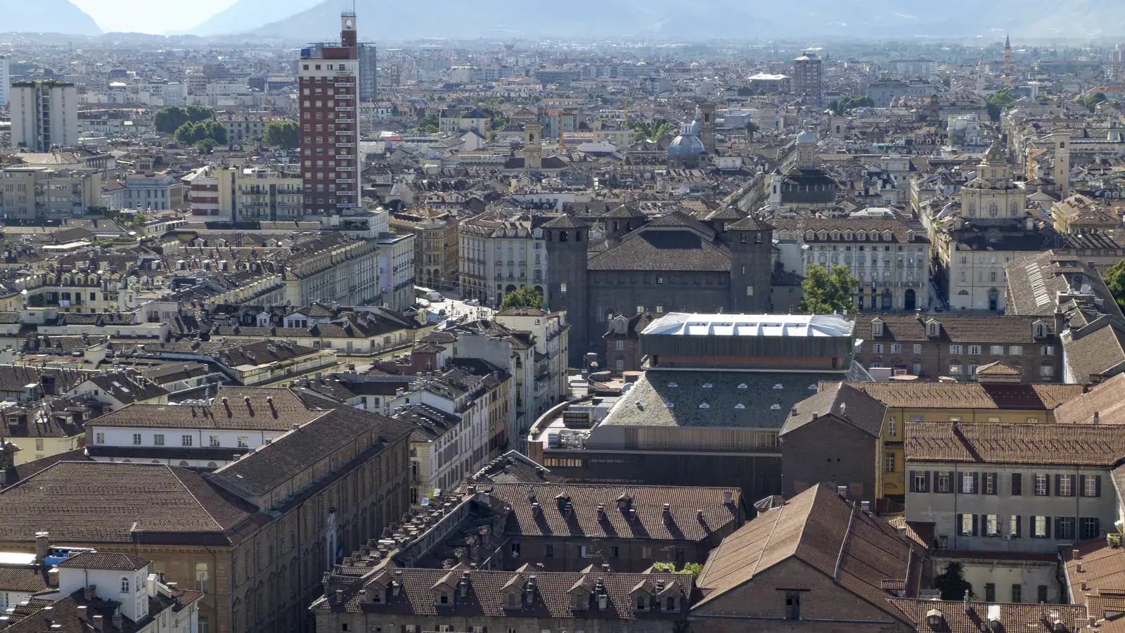 Dove dormire a Torino: i tetti del centro storico dall'alto, con la Torre Littoria e le Alpi