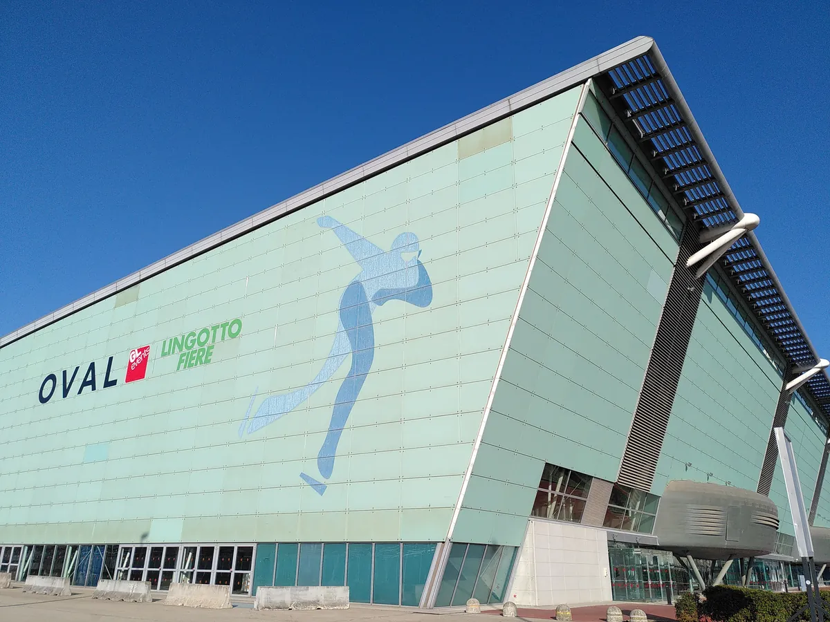 La facciata dell'Oval con le insegne OVAL e Lingotto Fiere sotto il cielo azzurro