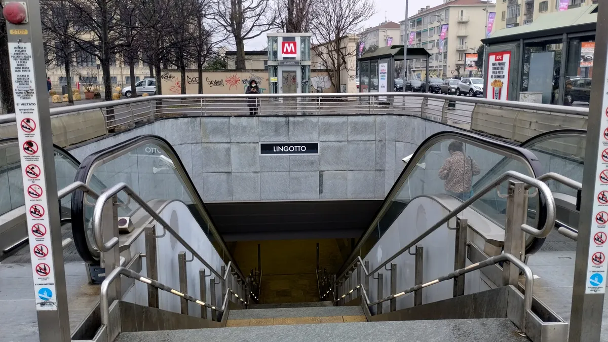 L'ingresso della fermata Lingotto della metro 1, con le scale mobili e il nome sul muro